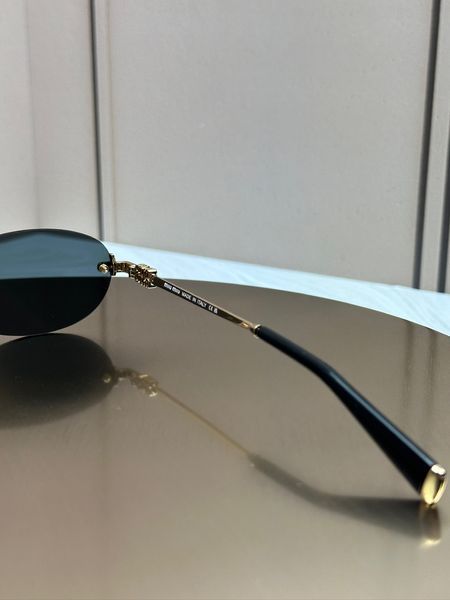 Солнцезащитные очки Miu Miu SMUA54 золотые овальные безободковые металлические, черная линза, женские